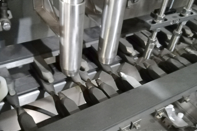 Precision dry material filling and dosing nozzle system